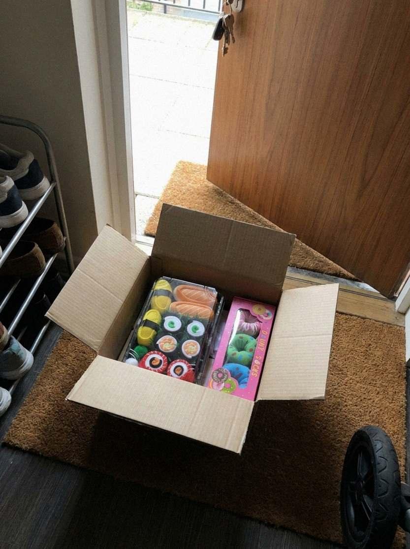 The shipping box on the doormat, with the sushi and donut boxes inside (AI-generated illustration)