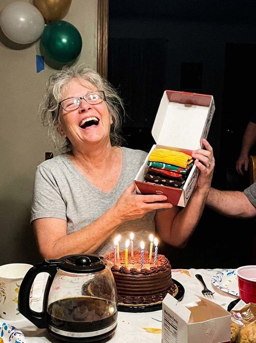 Grandma laughing at the birthday table, holding the burger box (AI-generated illustration)